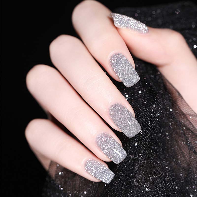 Sparkling glitter gel nail polish drying under a UV LED lamp for a long-lasting manicure