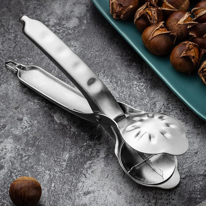 Stainless steel chestnut cracker with an open chestnut, demonstrating use