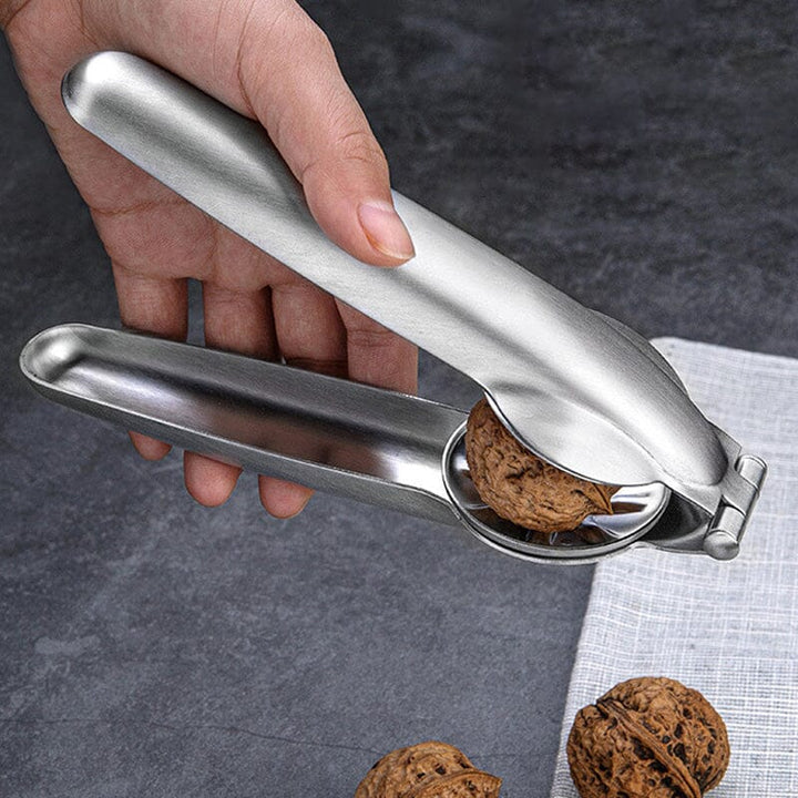 Hand holding stainless steel chestnut & nut cracker, easy grip design