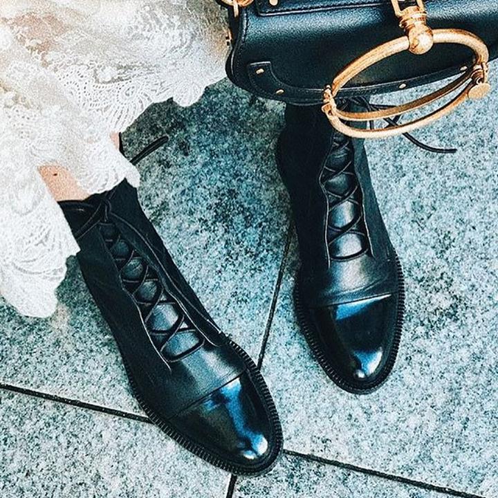Detailed shot of the robust lacing system on women's leather ankle boots, ensuring a secure and adjustable fit.