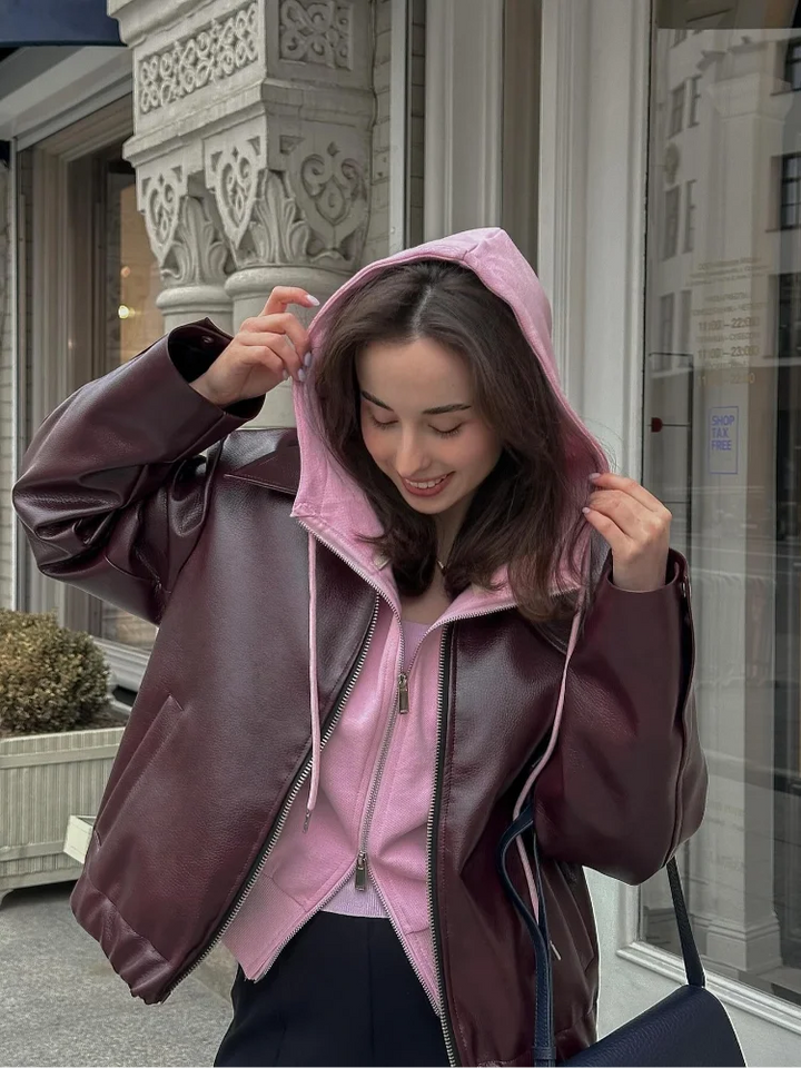 Chic women's brown leather short jacket with notched collar, great for fall and winter fashion. Versatile outerwear.