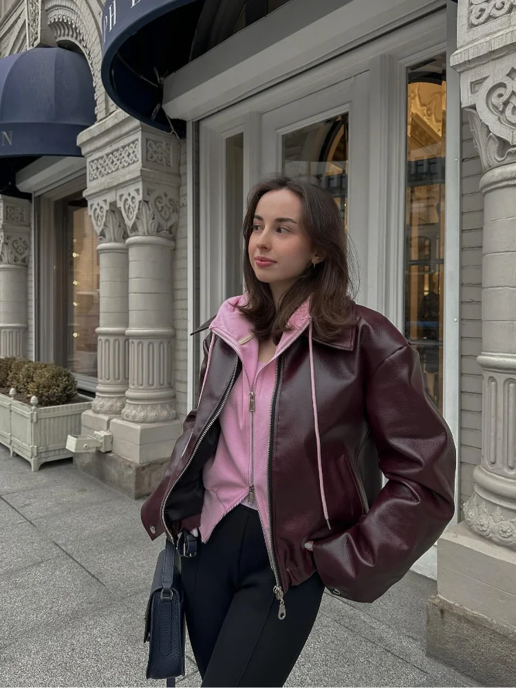 Women's brown leather short jacket with a distinctive notched collar. Zippered front, ideal for stylish fall wear.