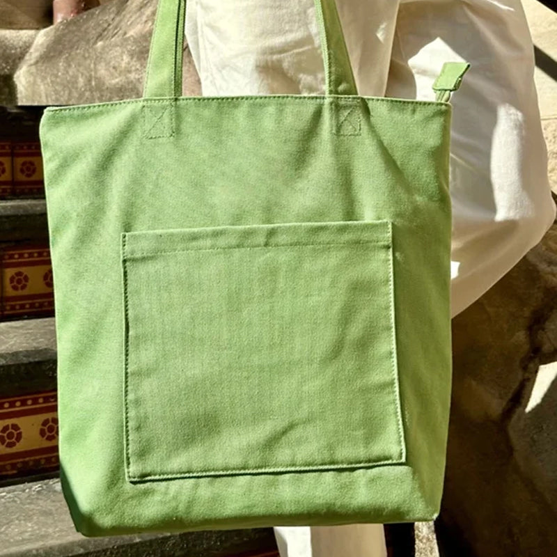 Front view of a versatile corduroy tote bag, showcasing its casual aesthetic and convenient pocket details.