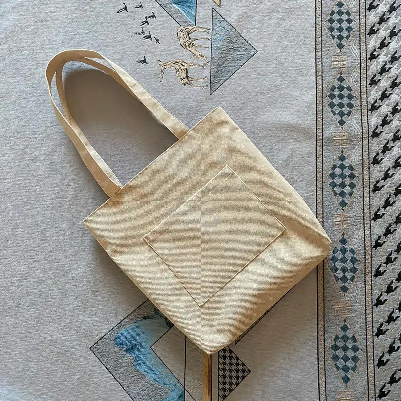 High-angle view of a women's corduroy tote bag, displaying its relaxed shape and capacity for various items.