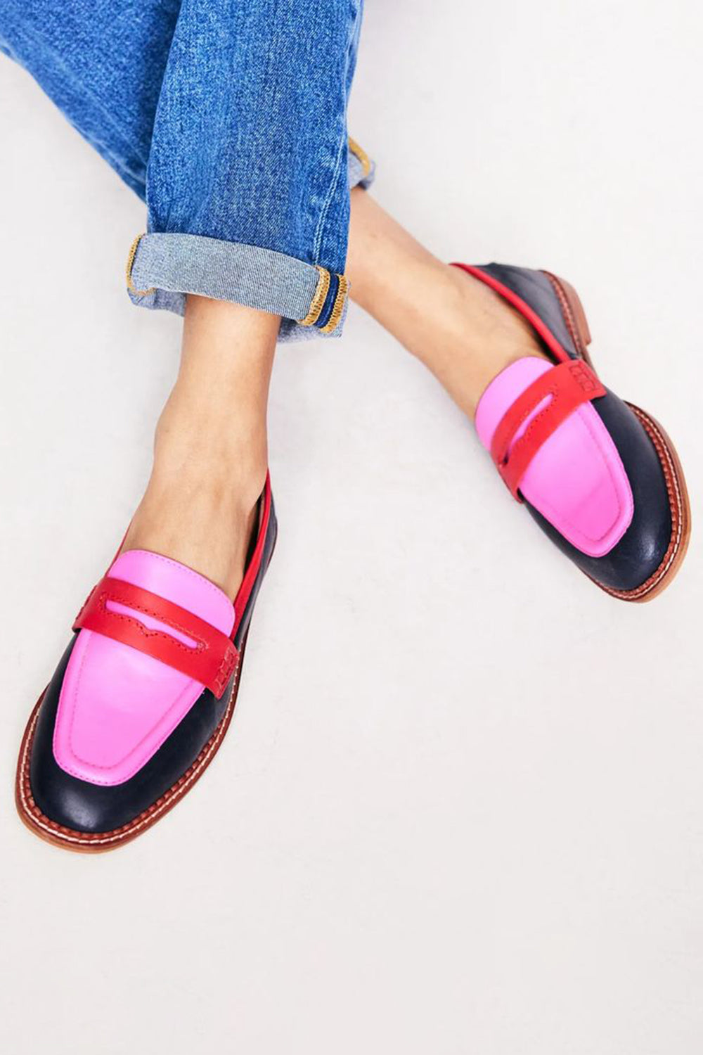 Stylish women's slip-on loafers with modern red and pink color-block design, comfortable for everyday wear.
