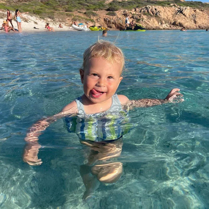 Toddler swim training float vest with built-in shorts and sun-protective long sleeves.