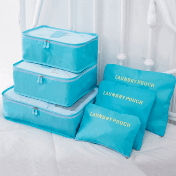 Open packing cube with folded clothes. Efficiently organize shirts, pants, & travel essentials for trips.