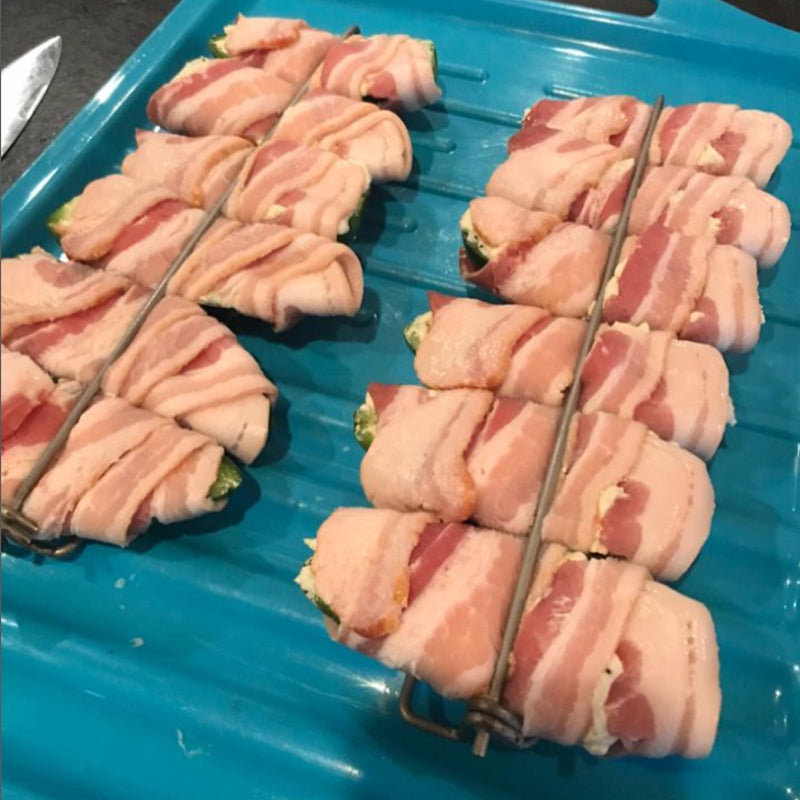 Preparing to grill with U-shaped metal skewers, loaded with chicken wings and gourmet sausages
