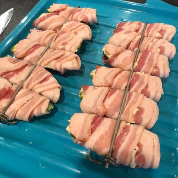 Preparing to grill with U-shaped metal skewers, loaded with chicken wings and gourmet sausages