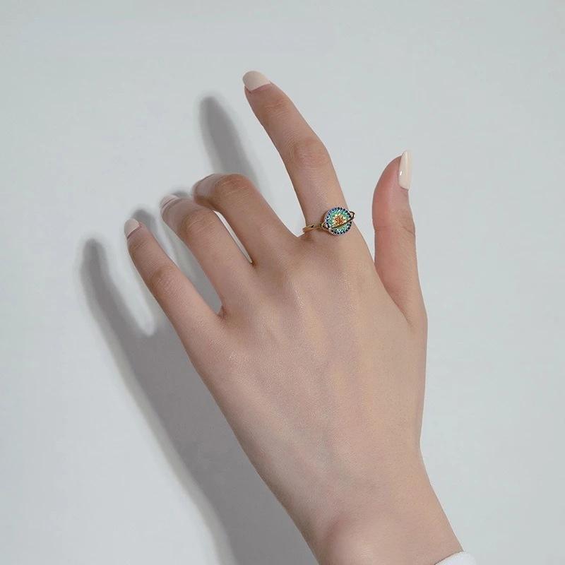 Close-up of a hand wearing a unisex adjustable galaxy fidget ring, showcasing the spinning mechanism for anxiety
