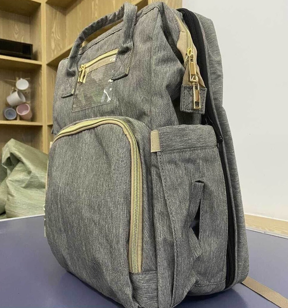 Deluxe baby gear: waterproof multi-pocket diaper backpack and foldable portable bassinet for travel.
