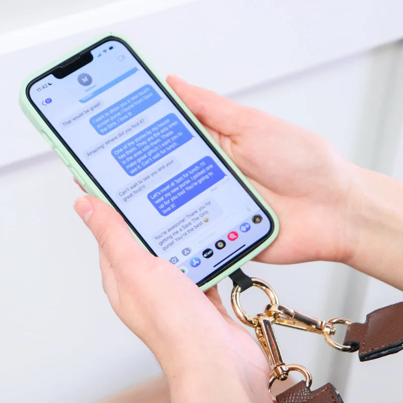Person wearing a versatile phone strap and pouch, demonstrating its use as a stylish hands-free accessory.
