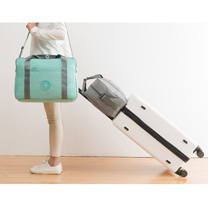 Multi-functional carry-on travel bag, usable as shoulder bag or suitcase attachment.