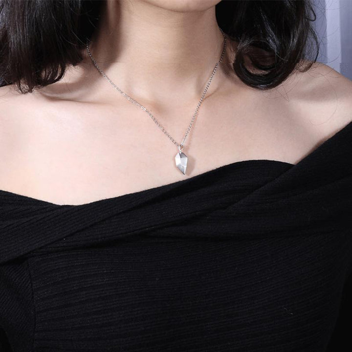 Detailed shot of two interlocking heart pendants from a unisex couple necklace set