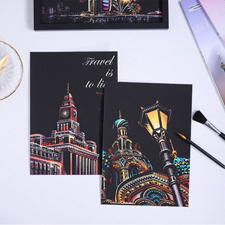 A hand holding a scratch tool, meticulously revealing colors on a night scene art board