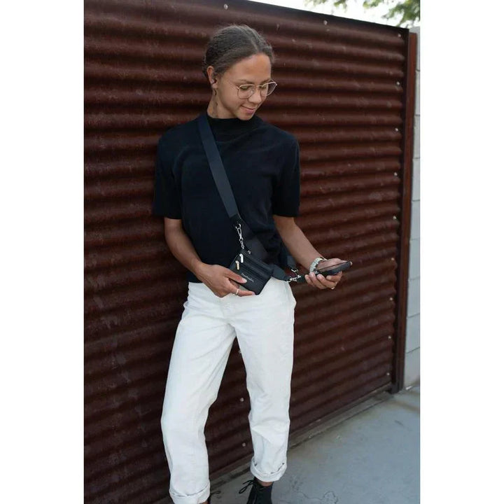 Tech accessory: black nylon crossbody phone holder with a zipper pouch, designed for effortless carrying.