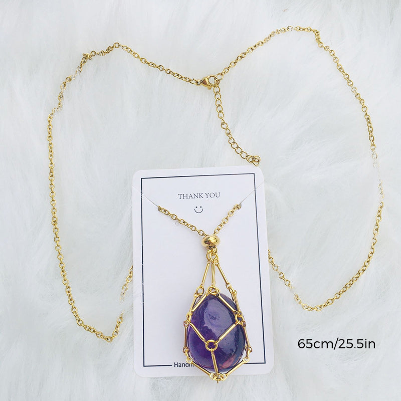 Empty silver crystal cage pendant necklace displayed on a wooden surface, earthy aesthetic