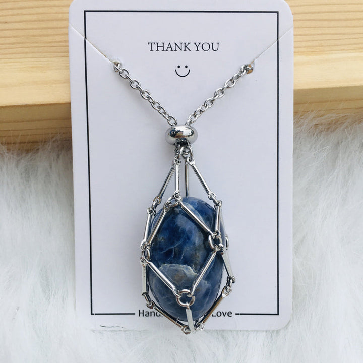 Gold crystal cage necklace, empty, against a dark background, elegant spiritual accessory