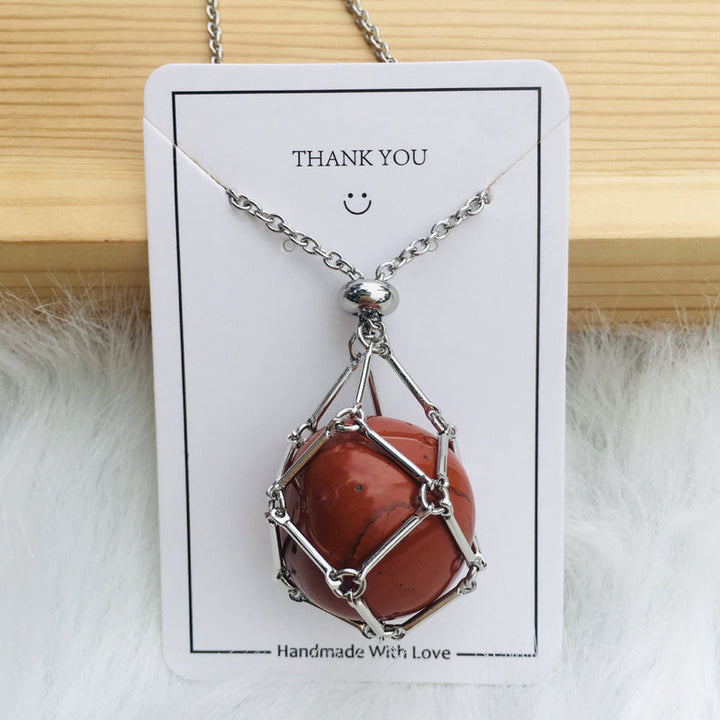Rose gold crystal cage pendant necklace, empty, on a marble surface, chic design