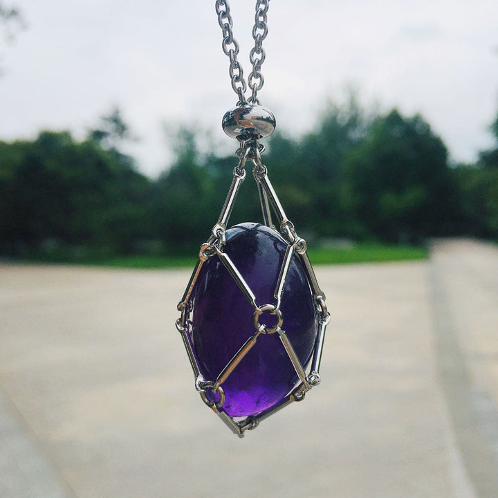 Silver crystal cage pendant shown open, revealing design for interchangeable healing stones