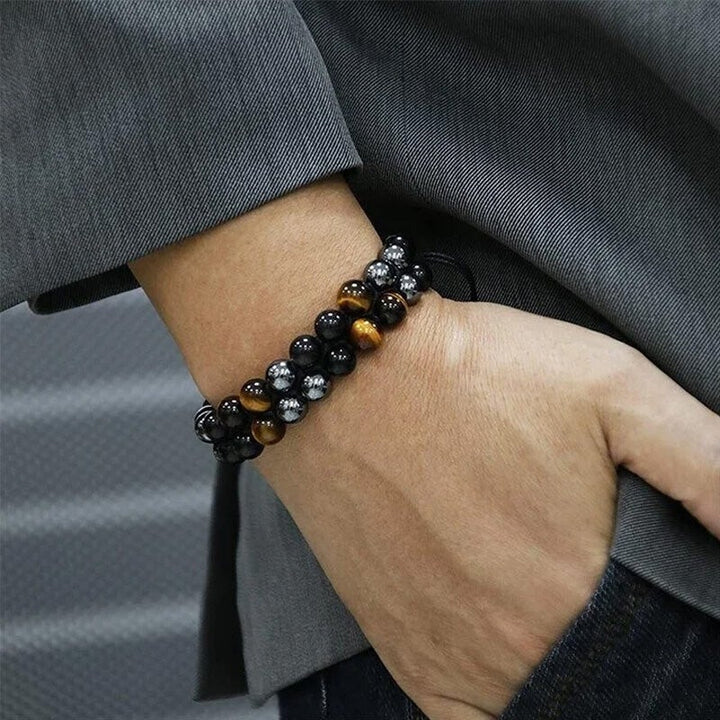 Close-up of a unisex protection bracelet featuring tiger's eye for courage and obsidian for grounding.