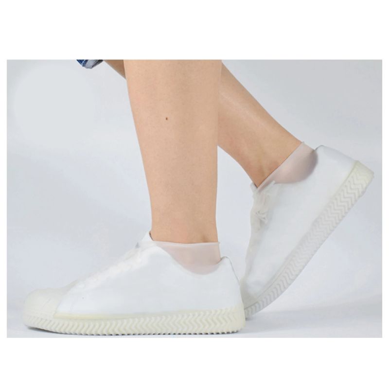 Person walking in rain, wearing DryStep reusable overshoes for ultimate shoe protection from wet weather.