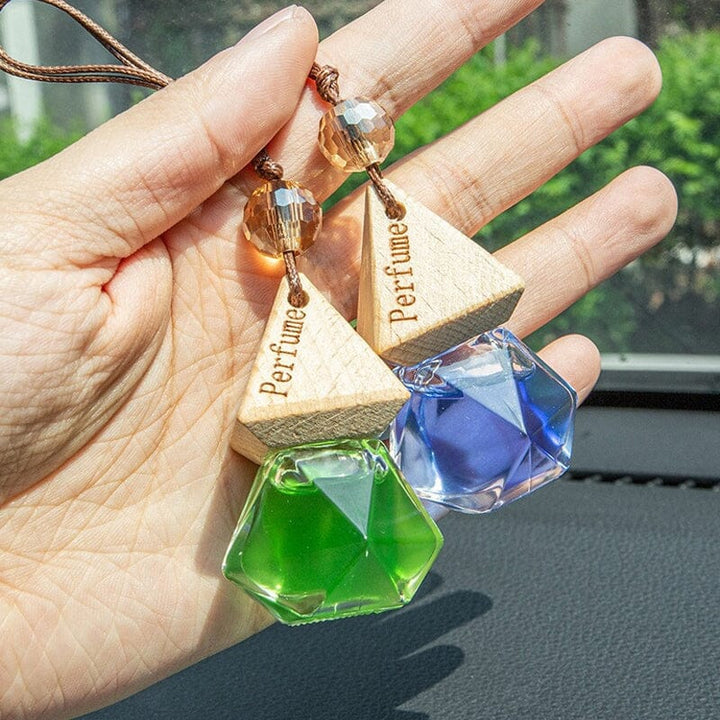 Close-up of a hanging car air freshener vial diffuser with wooden cap, auto accessory for car aroma
