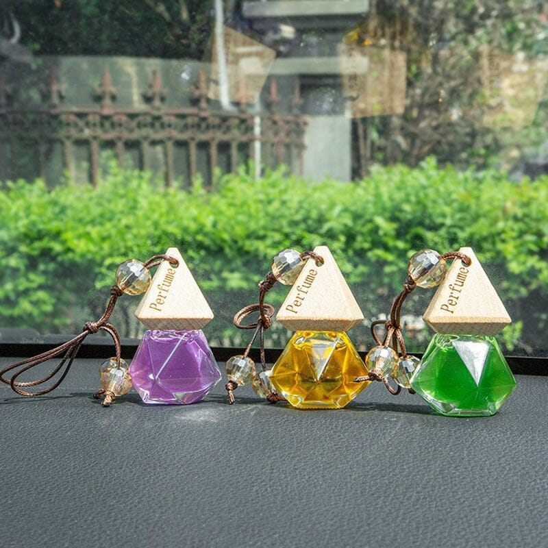 Car air freshener bottle, clear glass, dangling from a car mirror, adds fragrance & auto accessory decor