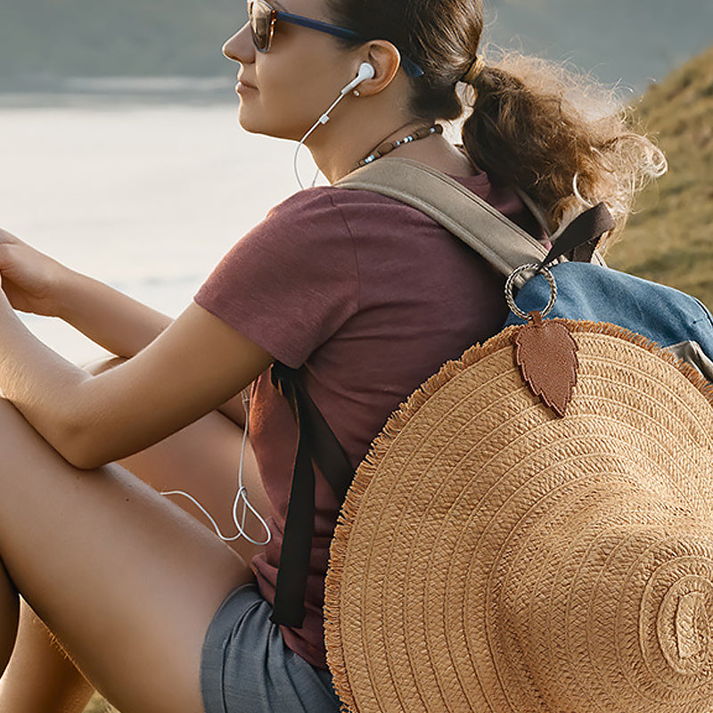 Unisex magnetic hat clip in black faux leather, attaches to bag for hands-free travel.