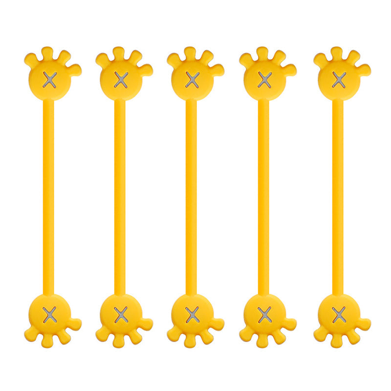 Two magnetic silicone cable organizer clips (yellow, orange) used side-by-side on a computer desk.