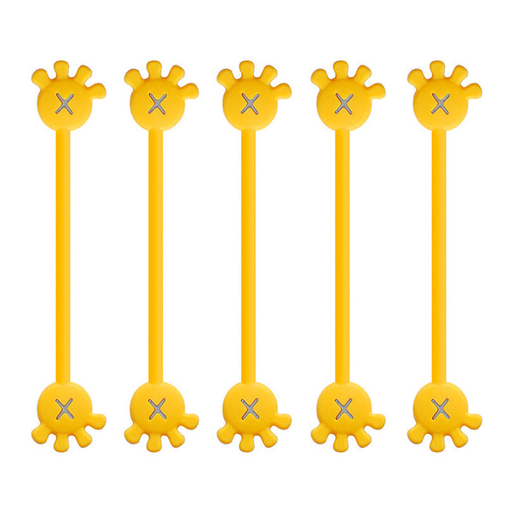 Two magnetic silicone cable organizer clips (yellow, orange) used side-by-side on a computer desk.