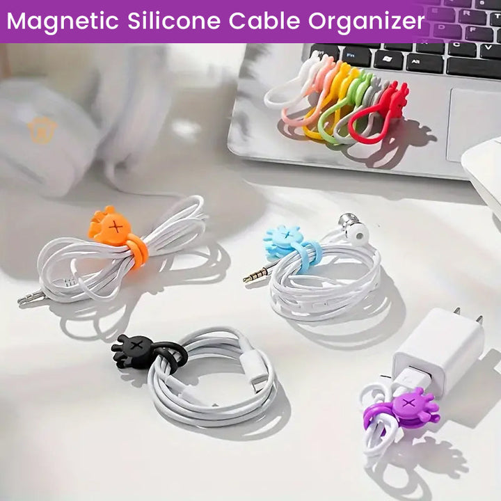 Close-up of a blue magnetic silicone cable organizer, holding two USB cords neatly on a white desk.