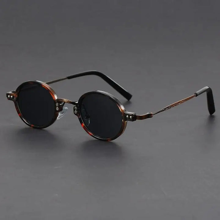 Unisex oval vintage sunglasses in black with precision lenses, a stylish eyewear accessory.
