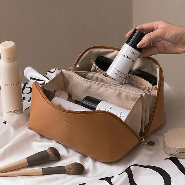 Unisex travel storage bag partially filled with daily cosmetics like lipstick, mascara, and a small mirror.