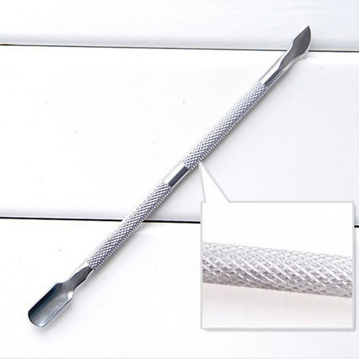 Close-up of a stainless steel cuticle pusher, showing its dual functional ends