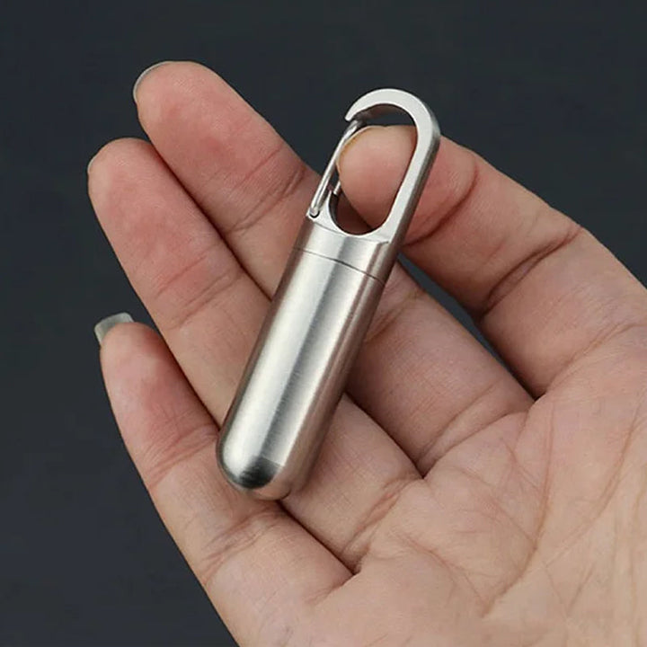 Compact travel pill container, stainless steel and waterproof, attached to a keychain