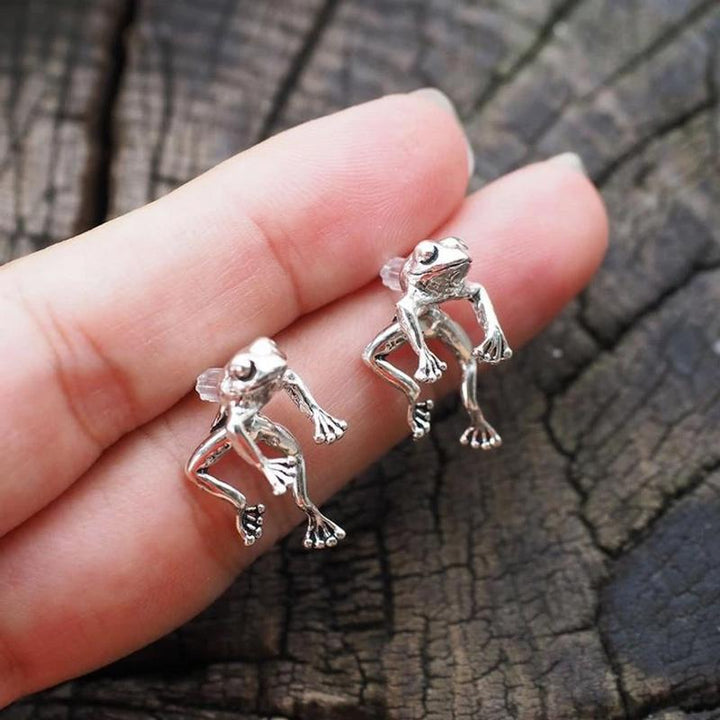 Close-up of a silver frog earring, highlighting its unique ear jacket style and vintage feel