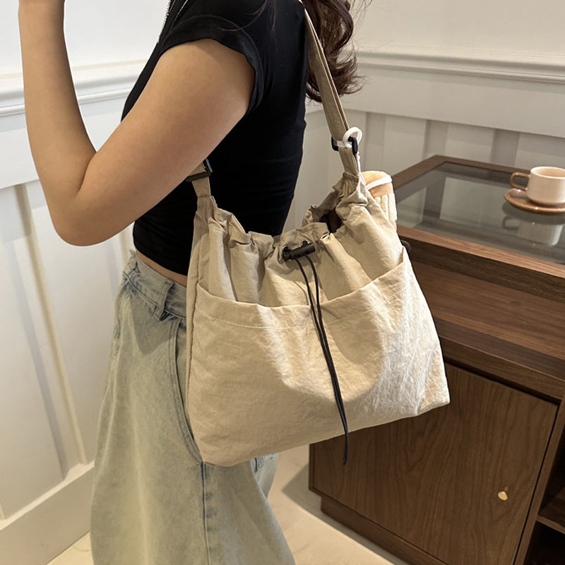 Model wearing black ultra-light messenger bag across body, casual and convenient for urban travel