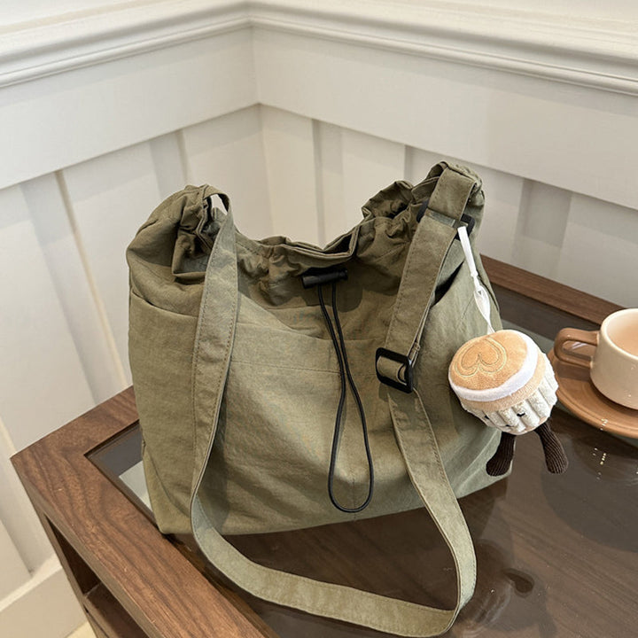 Unisex ultra-light messenger bag in black nylon, compact yet spacious for essential items, crossbody
