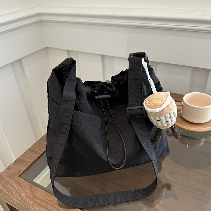 Top-down view of black ultra-light messenger bag, showcasing capacity and casual nylon finish