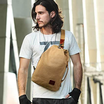 Close-up of the water-resistant canvas fabric and anti-theft zipper on a unisex crossbody bag.
