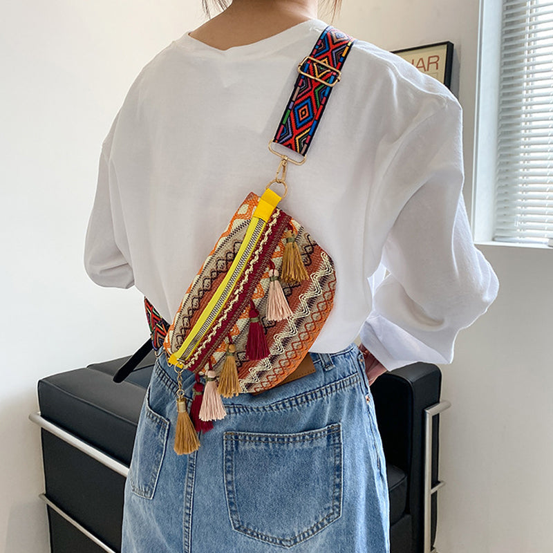 Model wearing a colorful woven bohemian shoulder bag, styled for a festival look.