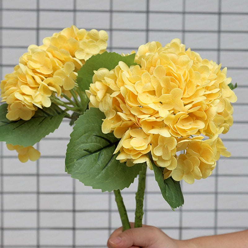 Artificial hydrangea bouquet with green foliage, adding a fresh and natural touch to home decor.