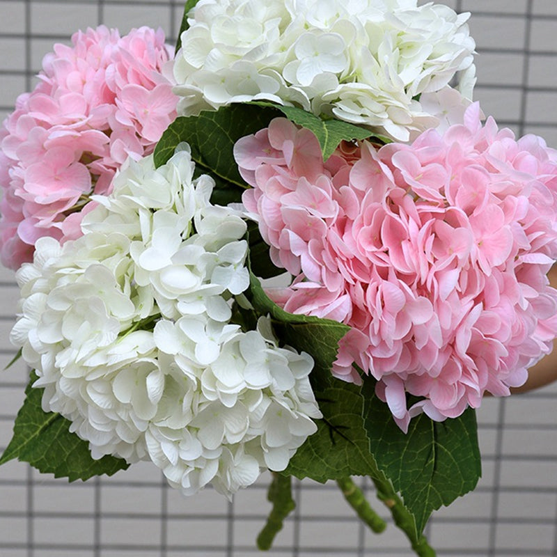 Artificial hydrangea bouquet in a vase, enhancing home decor with its vibrant fake plant petals.