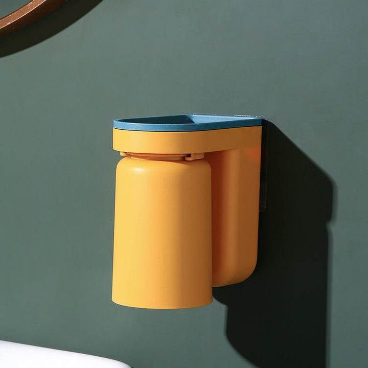 An organized bathroom counter with a wall-mounted toothbrush and cup holder, saving space.