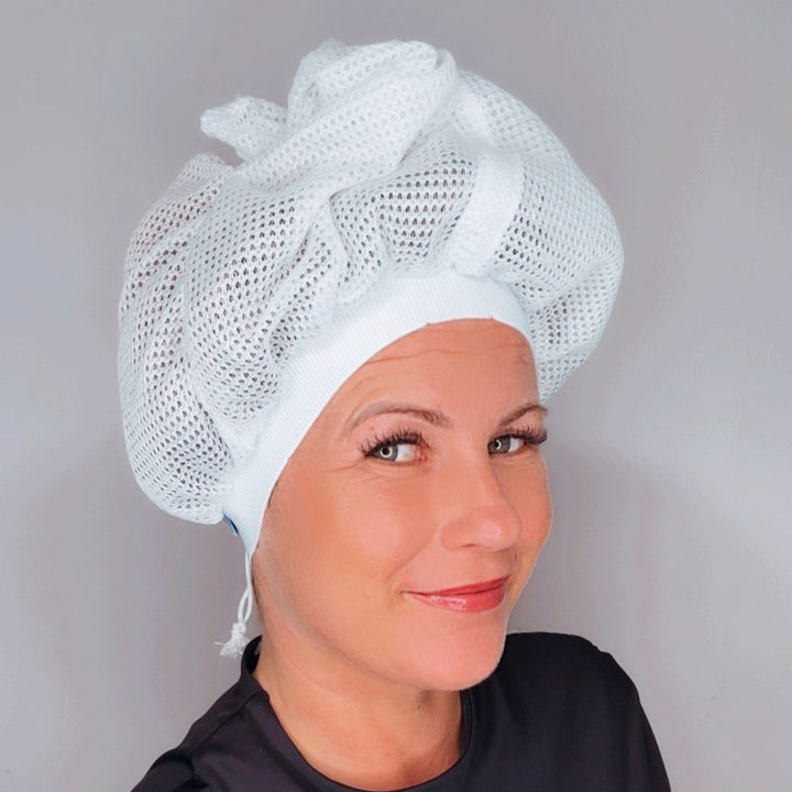 Flat lay of a plopping cap, curl enhancer product, and other hair accessories