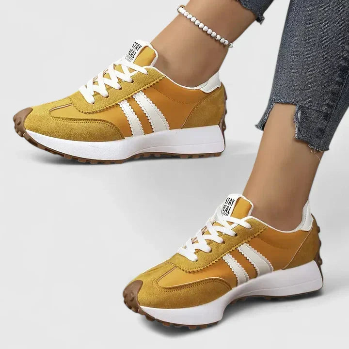 Sporty women's running trainers. White lace-up athletic shoes with a thick, comfortable chunky sole.