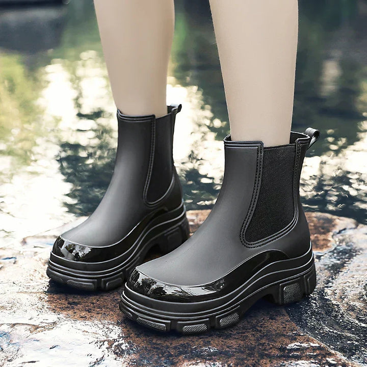 Fashion-forward women's chunky platform Chelsea rain boots. Waterproof black ankle boots perfect for stylish wet weather wear.