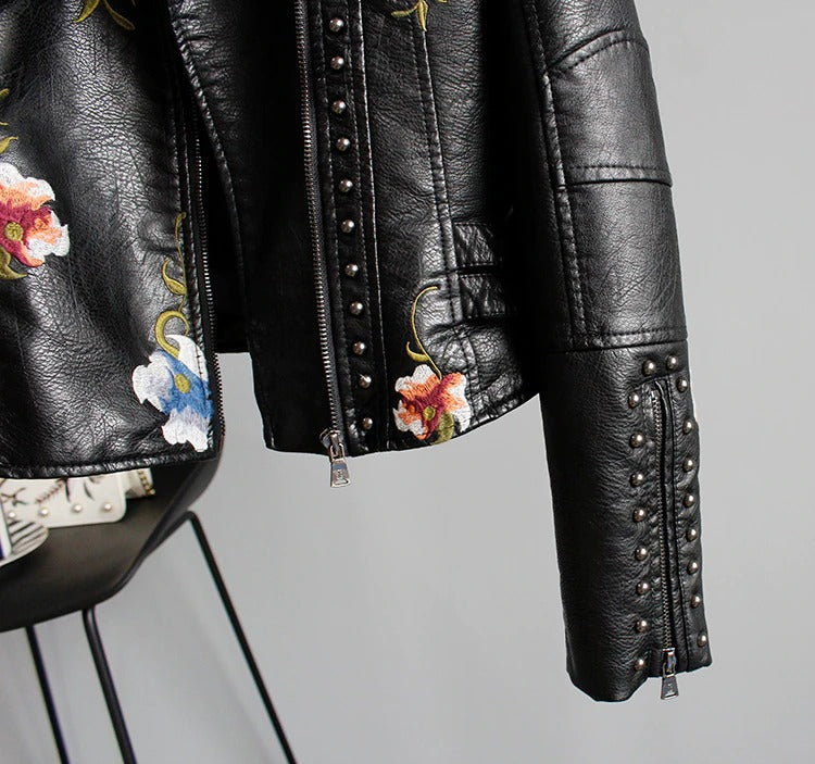 Chic embroidered women's biker jacket. Faux leather with floral details for an edgy style.