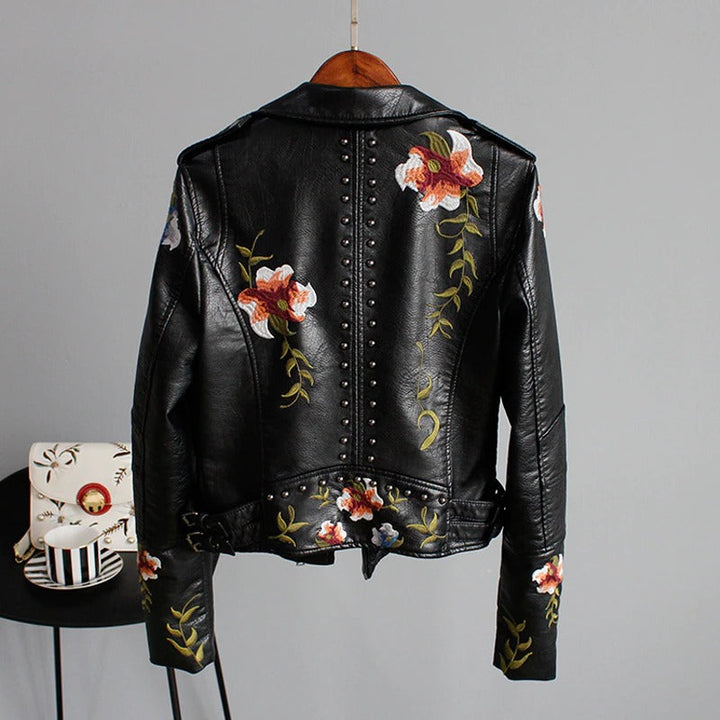 Studded and embroidered women's biker jacket in faux leather with a delicate floral design.
